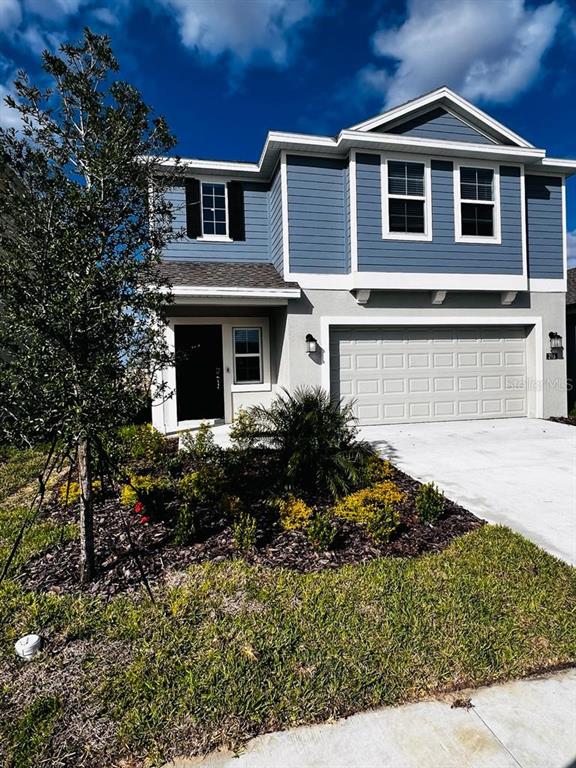A two-story blue house with a white garage and a small front garden — 215 AQUA AVENUE, DAVENPORT, FL