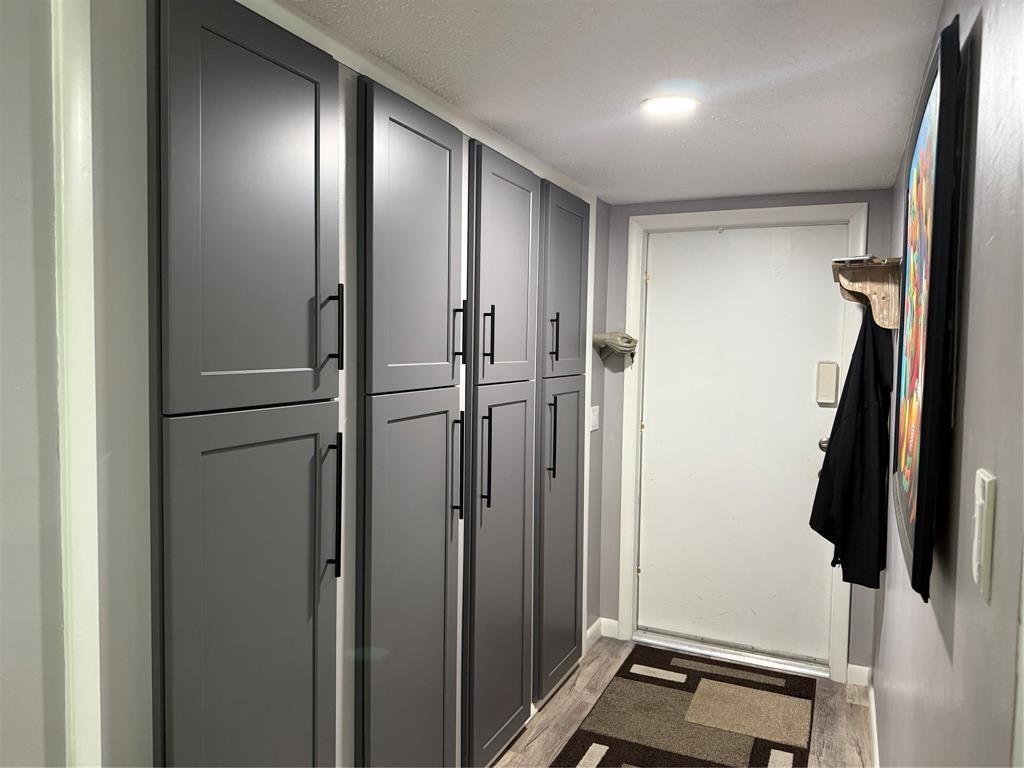 A hallway features tall gray cabinets with black hardware, a white door, and patterned flooring — 25 SE 13th Street # B2, Boca Raton FL 33432, BOCA RATON, FL