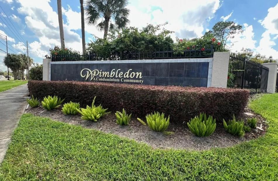 A sign for a condominium community stands behind a landscaped hedge and green lawn — 3244 S SEMORAN BOULEVARD UNIT 24, ORLANDO, FL