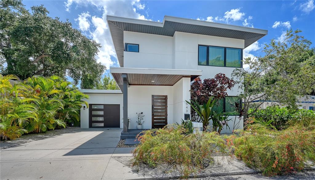 A modern two-story house features a flat roof, white exterior, and a wood-slatted front door — 543 COLUMBIA COURT, SARASOTA, FL