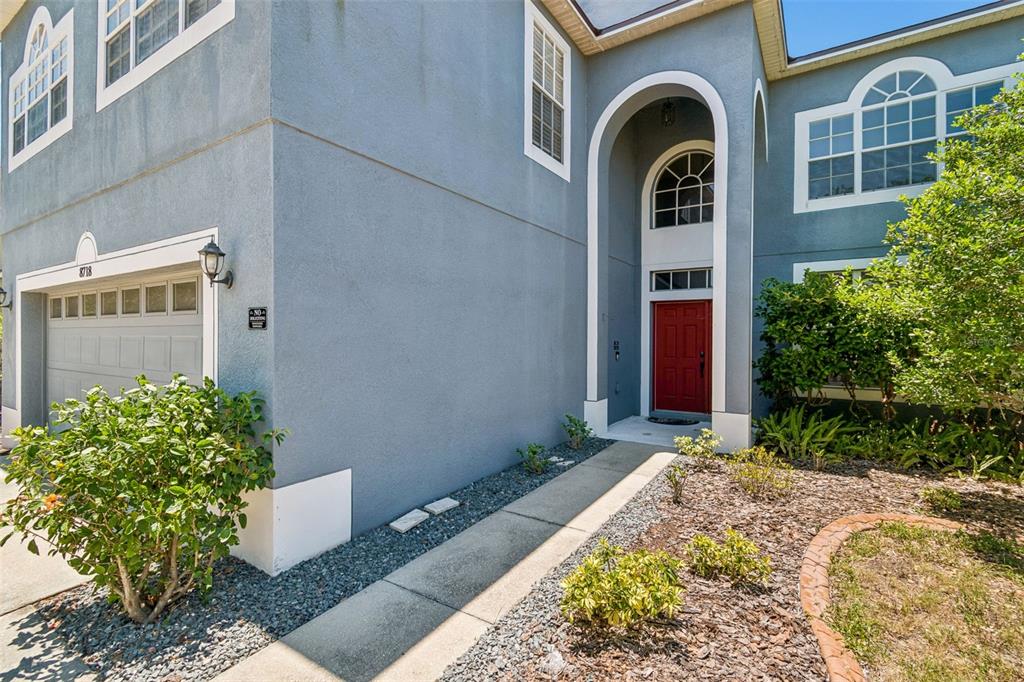 A two-story blue house with a red front door and an attached garage — 8718 SANDY PLAINS DRIVE, RIVERVIEW, FL