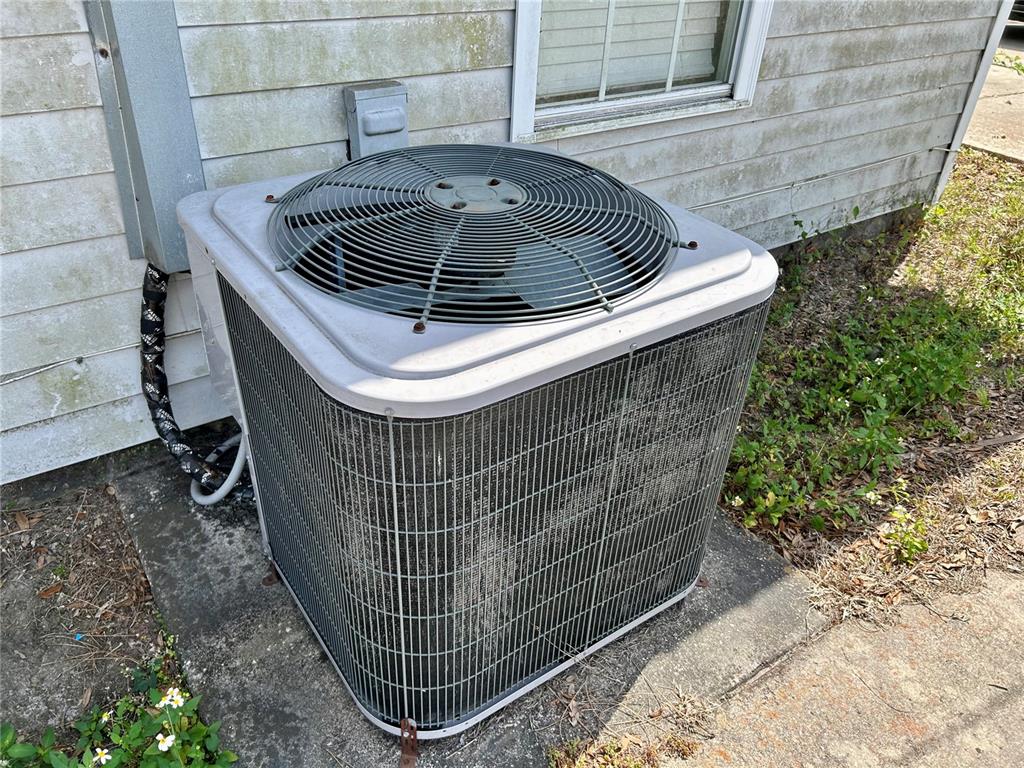 An outdoor air conditioning condenser unit sits on a concrete pad beside a house — 830 ALABAMA STREET, WAUCHULA, FL