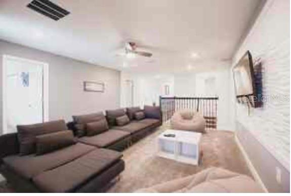 A spacious carpeted loft features a large sectional sofa, a white coffee table, and a television — 9024 SOMMERSET HILLS DRIVE, DAVENPORT, FL