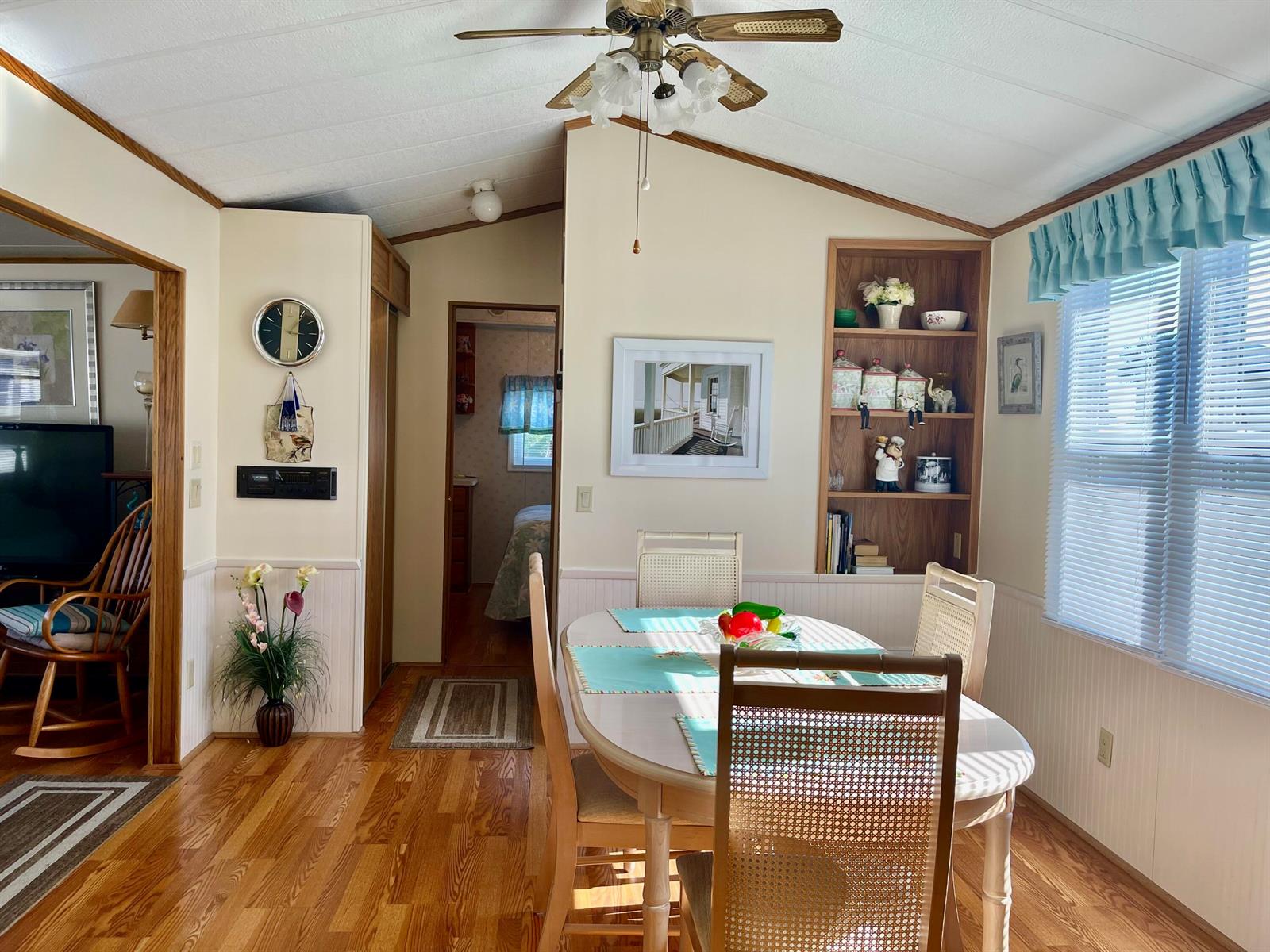 A dining area with a wooden table, chairs, built-in shelving, and hardwood flooring — 5374 SE 64th Avenue, Okeechobee FL 34974, OKEECHOBEE, FL