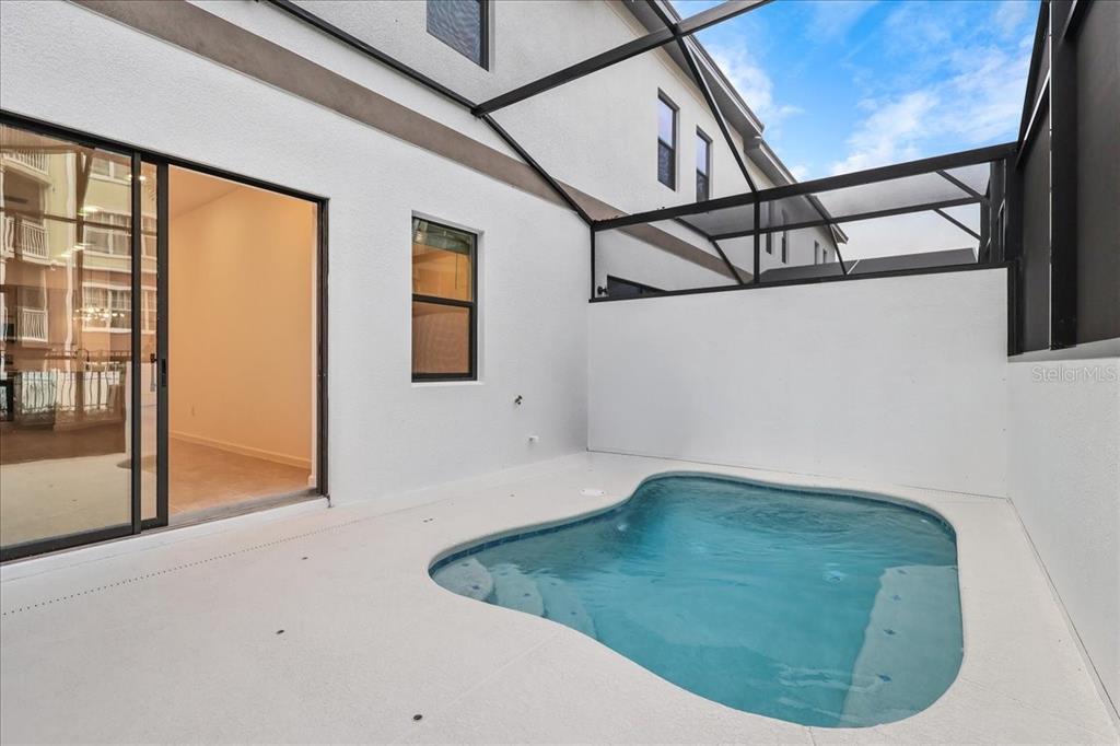 A small swimming pool sits on a patio enclosed by a screened-in lanai — 10525 EBB TIDE LANE, ORLANDO, FL
