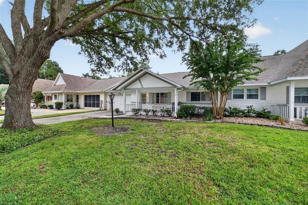 A single-story house with a white exterior, a front porch, and a large shade tree — 8526 SW 91ST STREET UNIT D, OCALA, FL