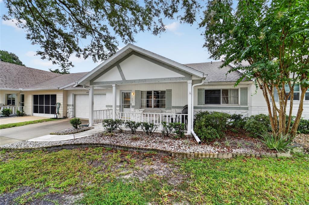 A single-story house with a white porch, gray trim, and a gravel front garden — 8526 SW 91ST STREET UNIT D, OCALA, FL