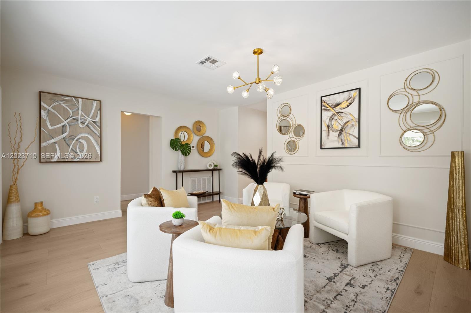 A living room features white armchairs, gold accents, wall molding, and a modern chandelier — 4220 SW 14th St, Miami FL 33134, MIAMI, FL