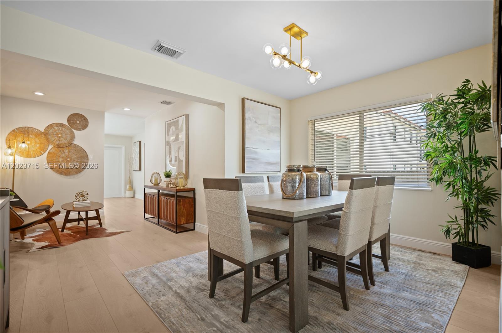 A dining room features a wooden table, upholstered chairs, a modern chandelier, and hardwood floors — 4220 SW 14th St, Miami FL 33134, MIAMI, FL