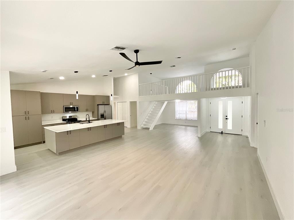 A spacious open-concept living area features a modern kitchen with an island and a loft — 1307 BELCHER DRIVE, TARPON SPRINGS, FL
