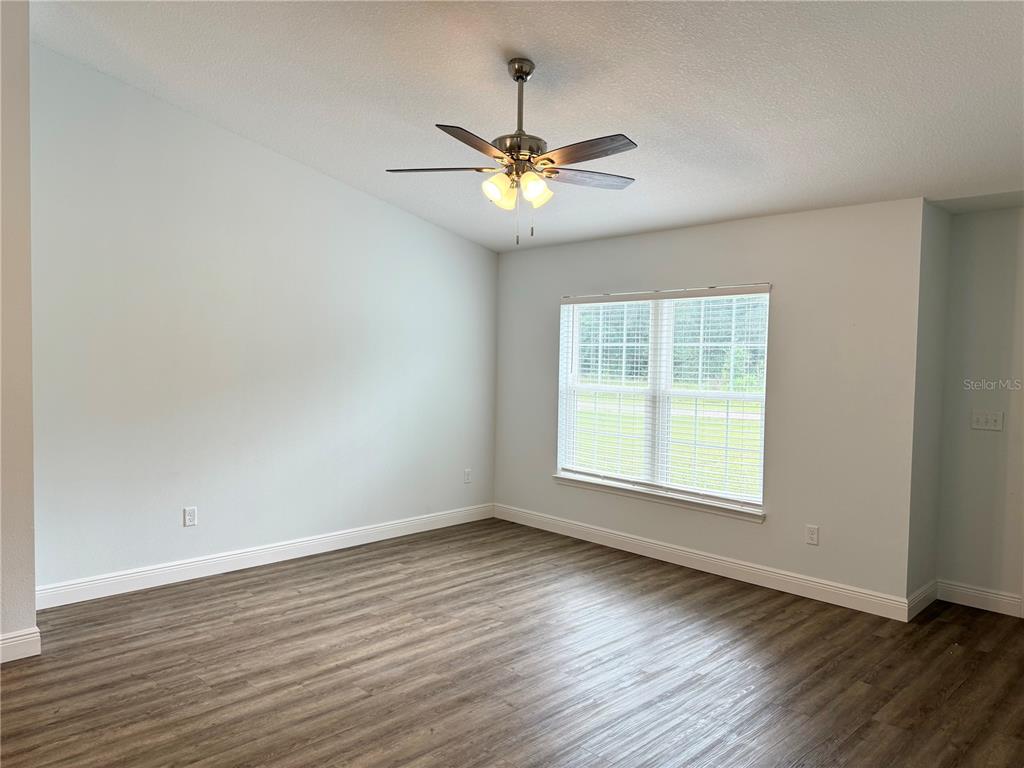 An empty room with light walls, wood-look flooring, a ceiling fan, and a window — 7752 N WALTON TERRACE, CITRUS SPRINGS, FL