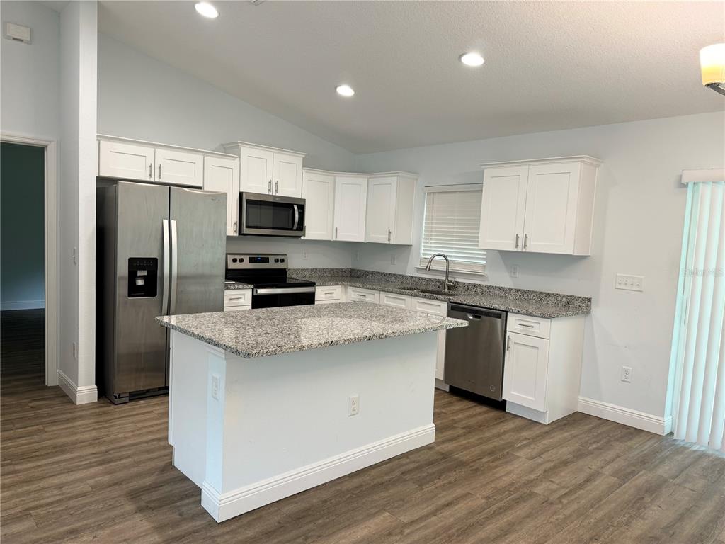 A kitchen features white cabinets, granite countertops, stainless steel appliances, and a central island — 7752 N WALTON TERRACE, CITRUS SPRINGS, FL