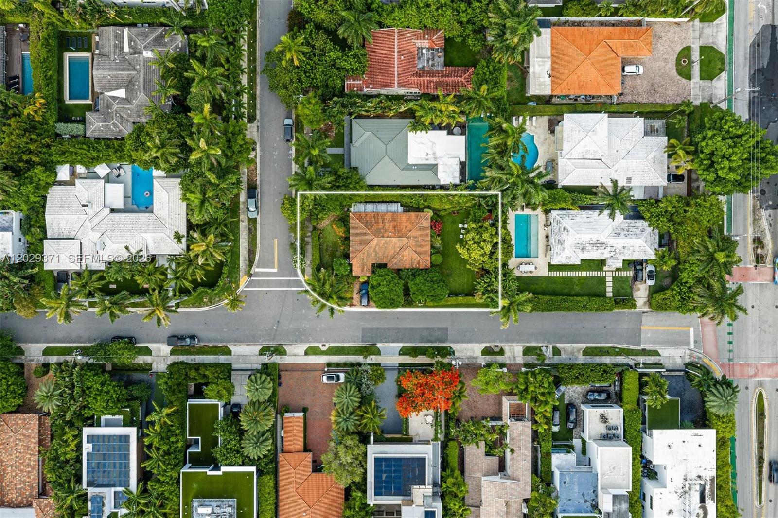 An aerial view shows a single-story house with a tiled roof surrounded by lush landscaping — 455 W Dilido Dr, Miami Beach FL 33139, MIAMI BEACH, FL