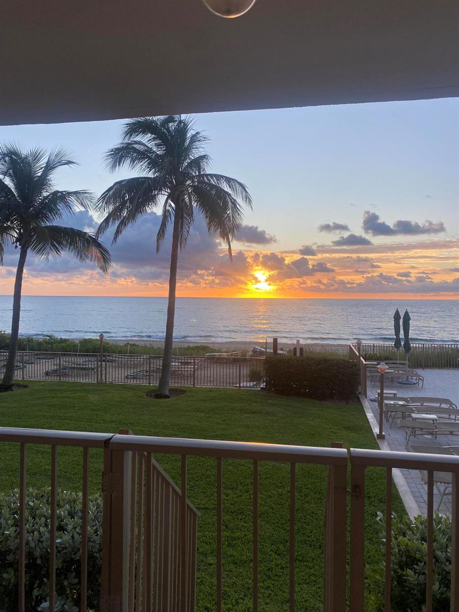 A view of the ocean and beach at sunset from a balcony with palm trees — 1021 Hillsboro Mile # G6, Hillsboro Beach FL 33064, HILLSBORO BEACH, FL
