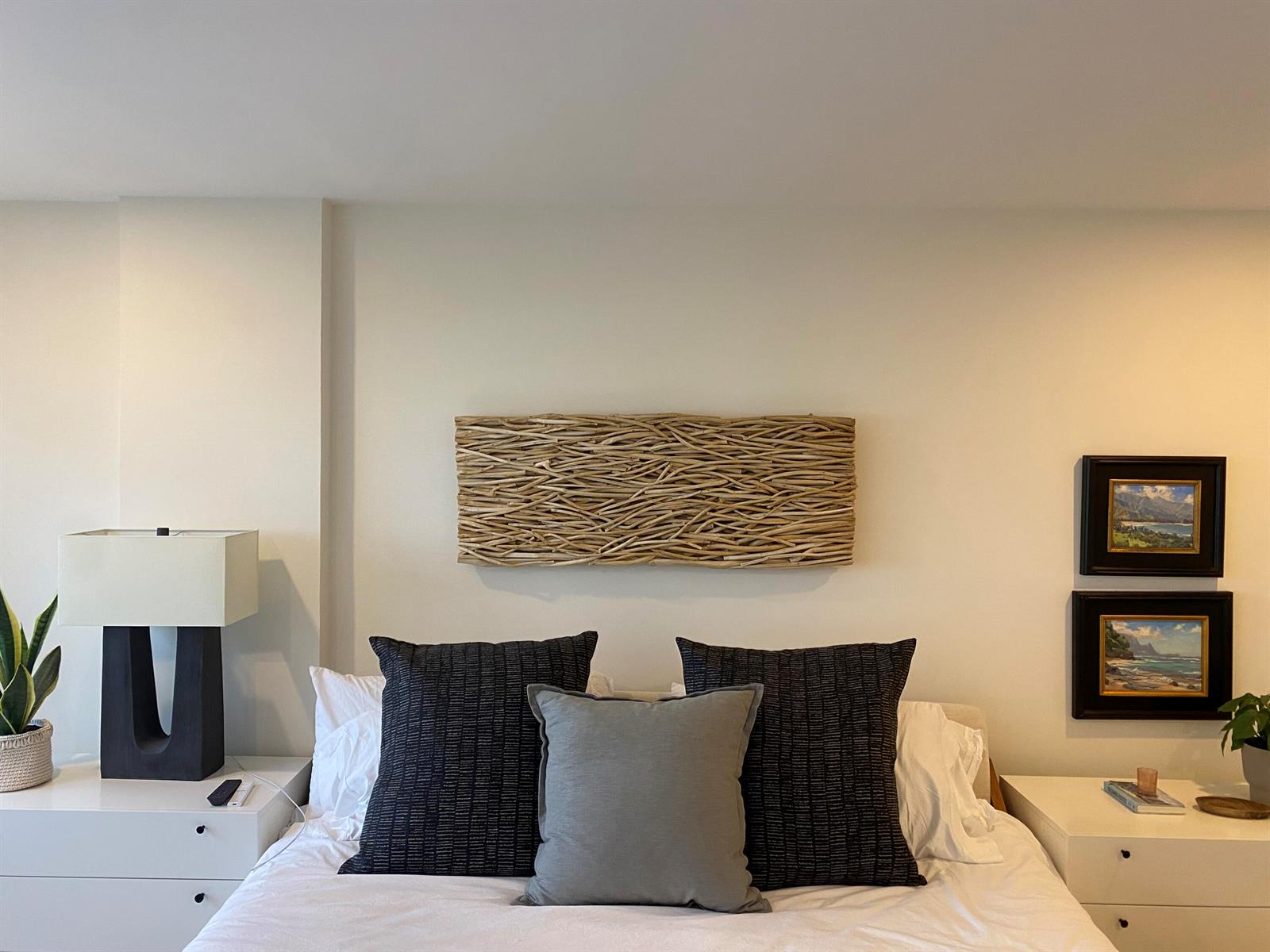 A bedroom features a central driftwood wall art piece above a bed with dark pillows — 1021 Hillsboro Mile # G6, Hillsboro Beach FL 33064, HILLSBORO BEACH, FL