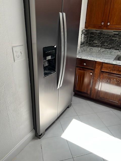 A stainless steel refrigerator stands next to dark wood cabinets and a granite countertop — 53 21ST TERRACE SE, LARGO, FL