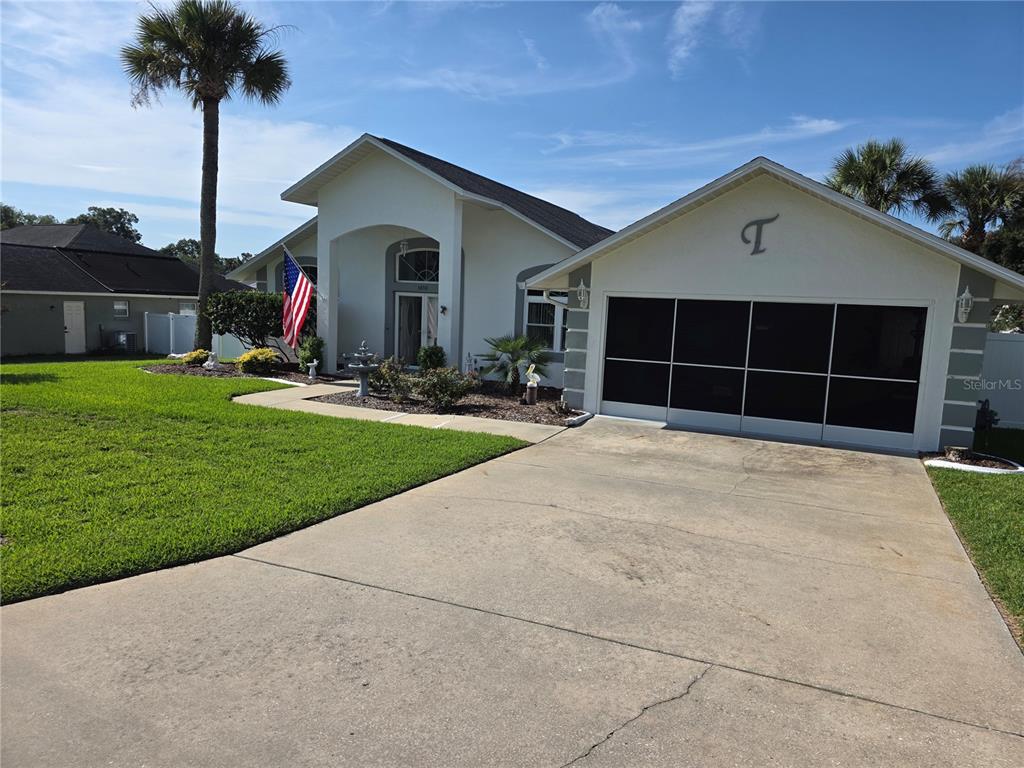 A single-story house with a white exterior, a two-car garage, and a palm tree — 3850 SE 59TH PLACE, OCALA, FL