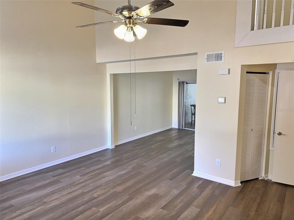 A living room with wood-look flooring, a ceiling fan, and a doorway leading outside — 1257 WINTER GREEN WAY, WINTER GARDEN, FL