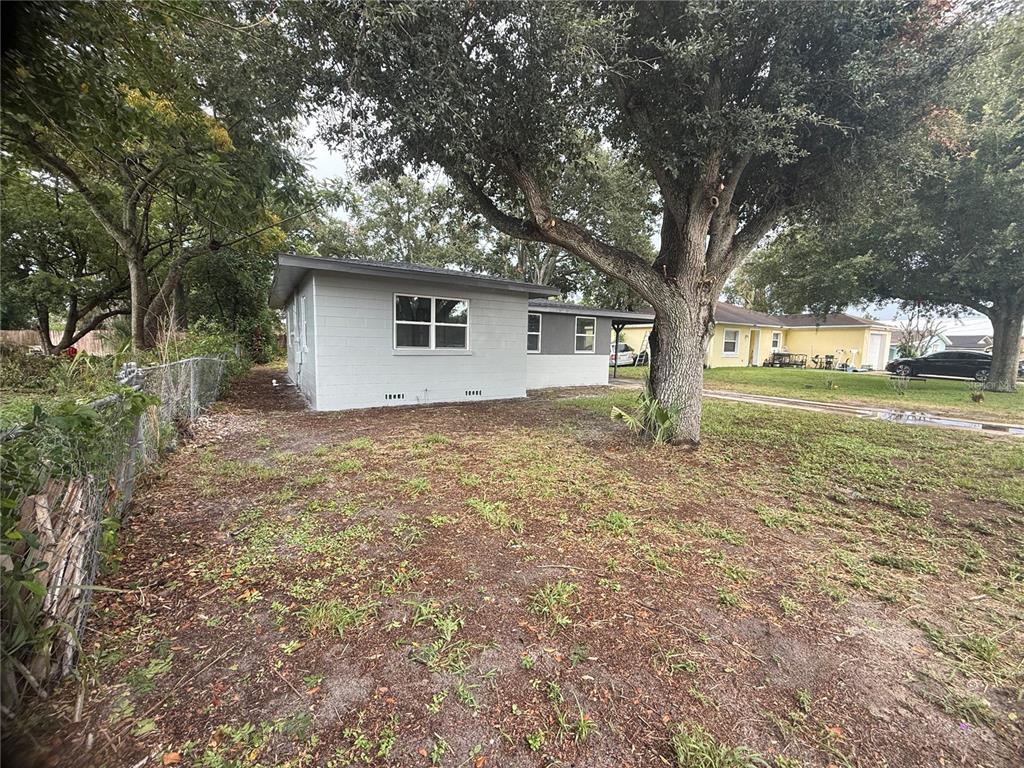 A grey concrete block house with a large tree in the front yard — 309 1ST STREET, AUBURNDALE, FL