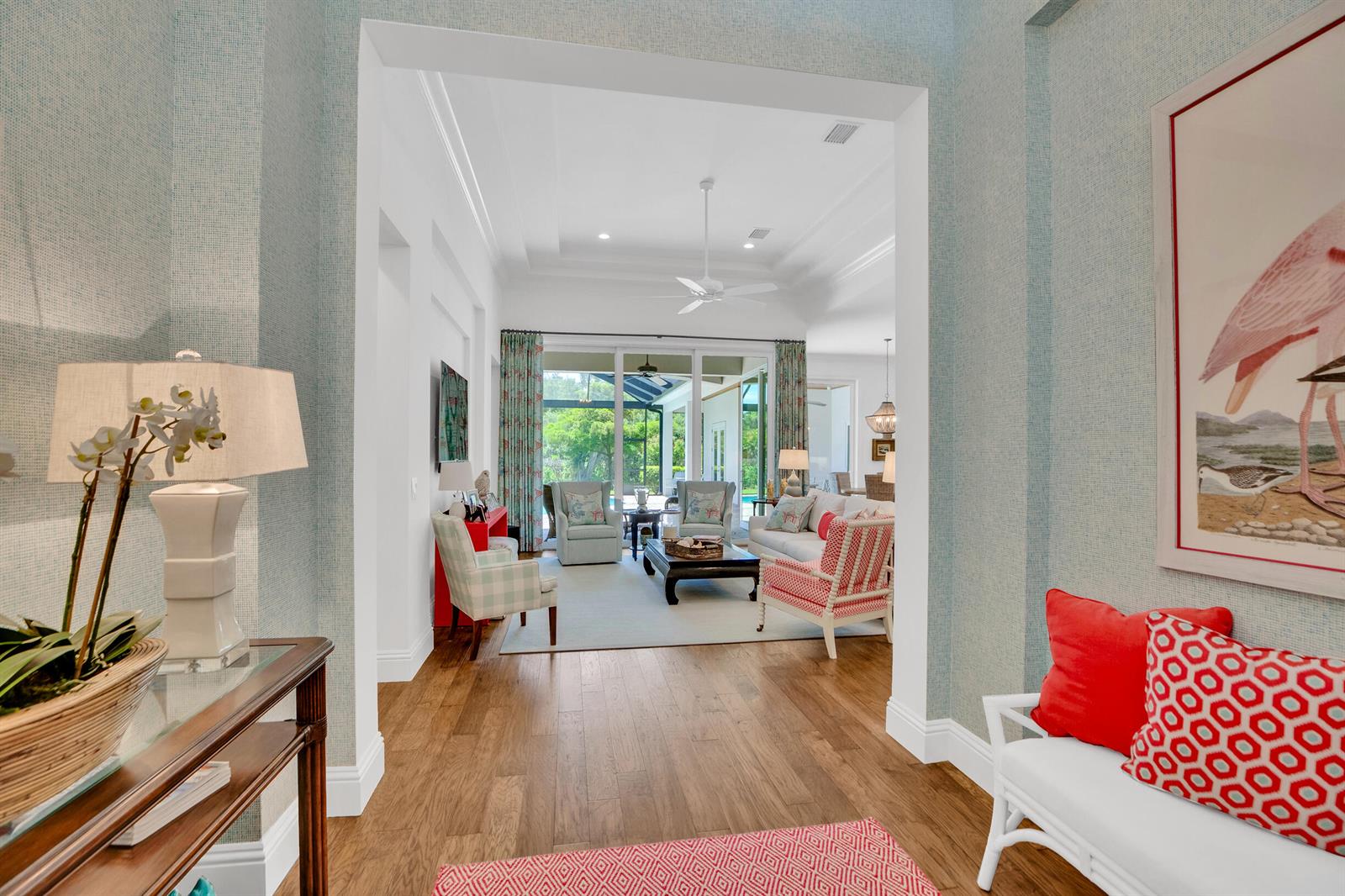 A view from a foyer into a living room with hardwood floors and patio access — VERO BEACH, FL