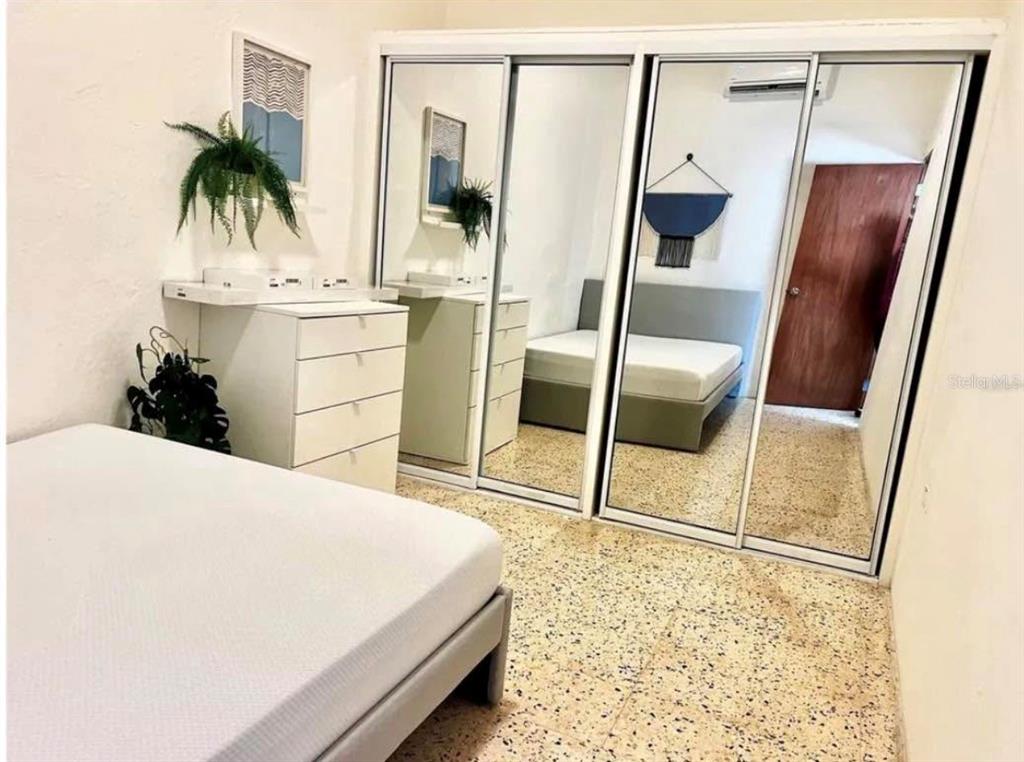 A bedroom features a bed, a white dresser, and large mirrored sliding closet doors — 119 STA CECILIA, SAN JUAN, PR