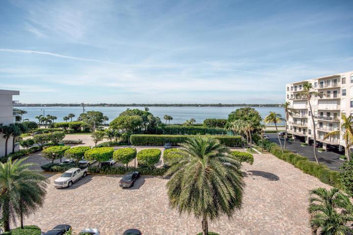 An elevated view of a paved parking lot with palm trees and a waterfront background — 3250 S Ocean Boulevard # 507n, Palm Beach FL 33480, PALM BEACH, FL