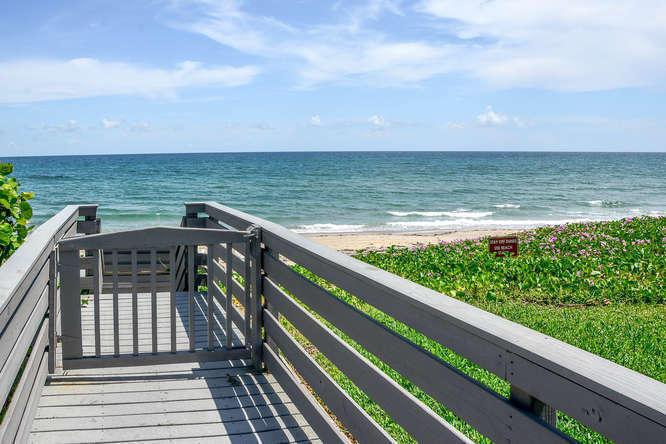 A wooden walkway with a gate leads toward a sandy beach and the ocean — 3250 S Ocean Boulevard # 507n, Palm Beach FL 33480, PALM BEACH, FL