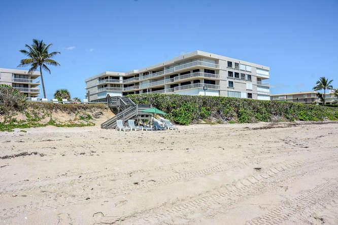 A multi-story beachside apartment building sits behind a sandy beach with a wooden staircase — 3250 S Ocean Boulevard # 507n, Palm Beach FL 33480, PALM BEACH, FL