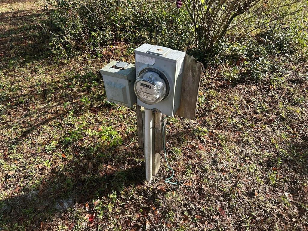 An outdoor electrical meter and service panel mounted on a wooden post in a yard — 31304 HILLSIDE DRIVE, DELAND, FL