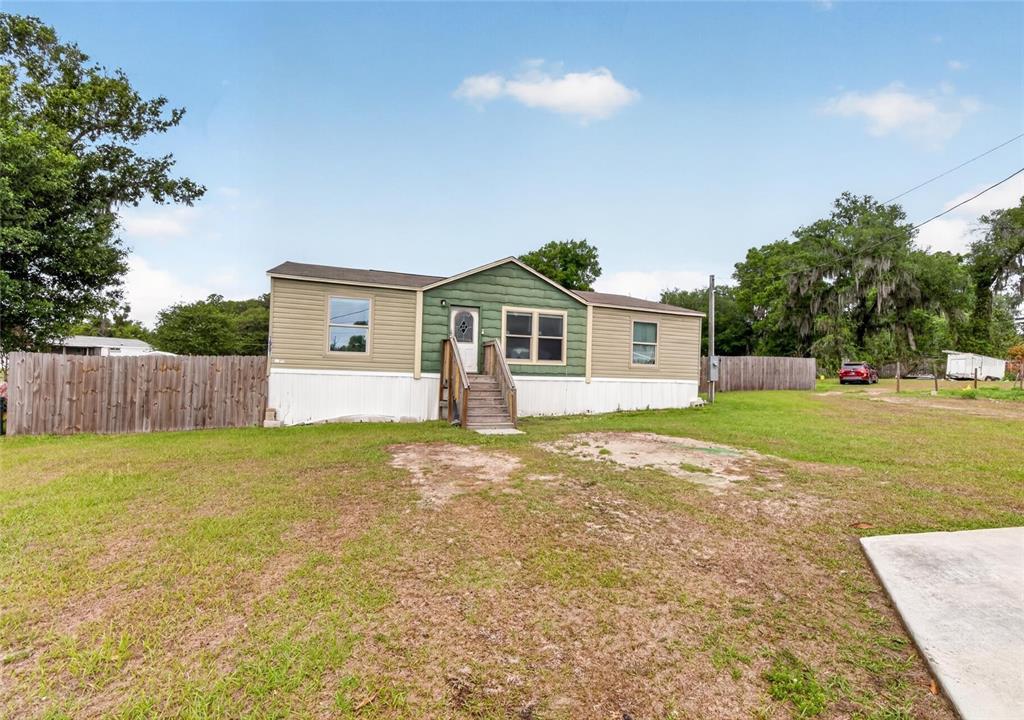 A single-story manufactured home with green and tan siding sits on a grassy lot — 3991 SHADY COURT, MULBERRY, FL