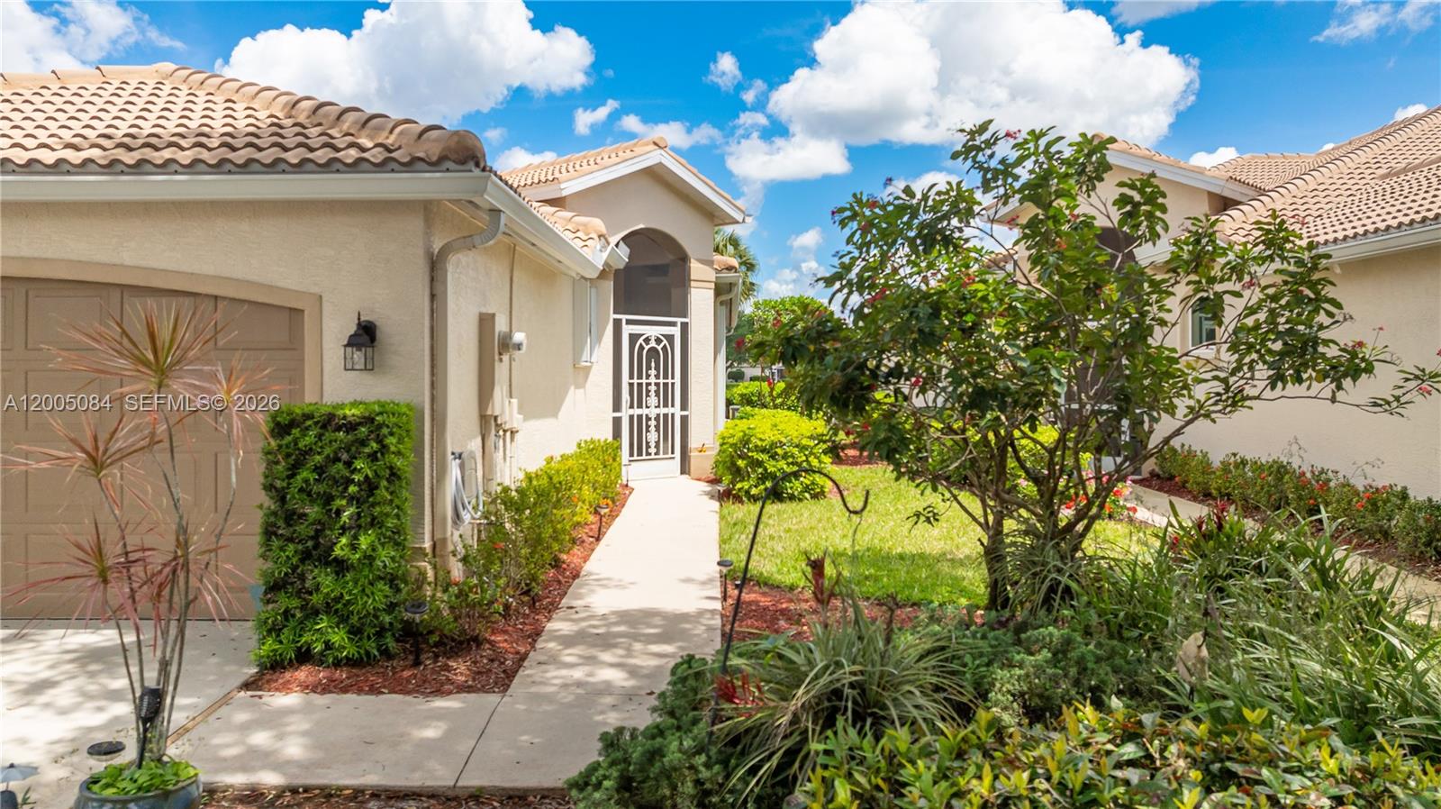A concrete walkway leads to the front entrance of a house with a tile roof — 1896 Crestview Way, Naples FL 34119, NAPLES, FL