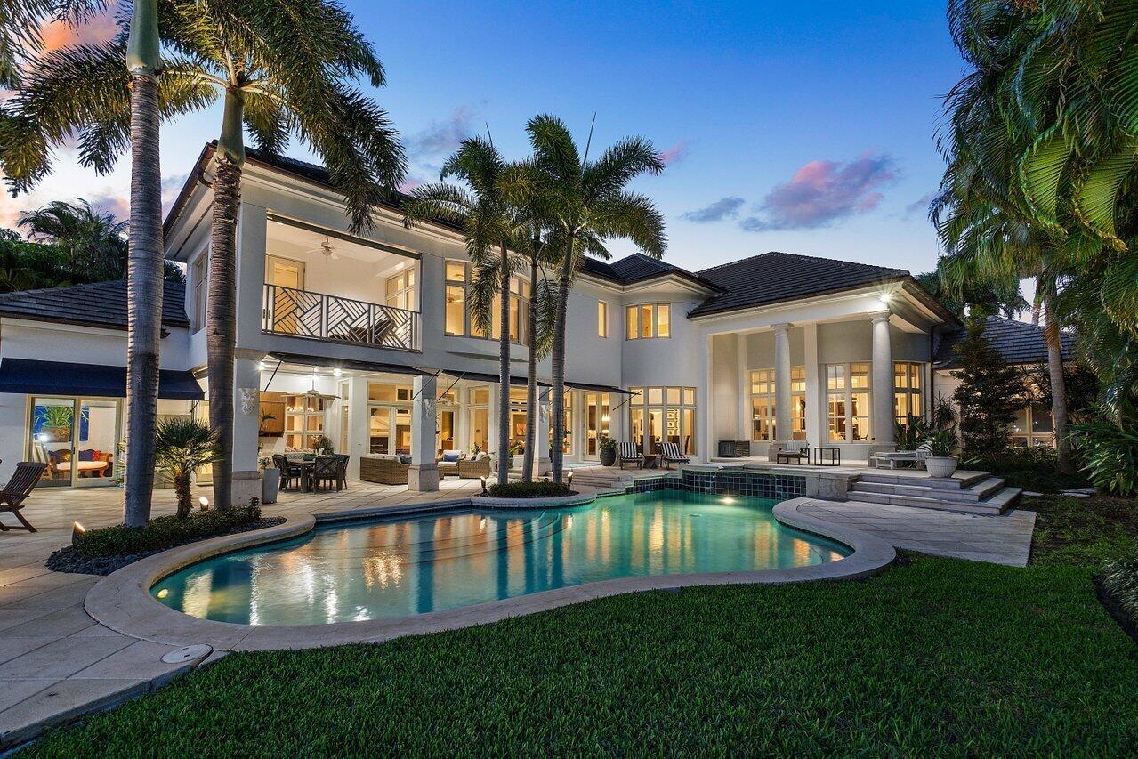 A two-story house with a swimming pool, palm trees, and a covered patio at dusk — 616 Seasage Drive, Delray Beach FL 33483, DELRAY BEACH, FL