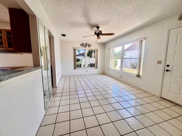 A dining area features white tile flooring, a ceiling fan, and a large window — 641 LINDEN DRIVE UNIT 328, ENGLEWOOD, FL