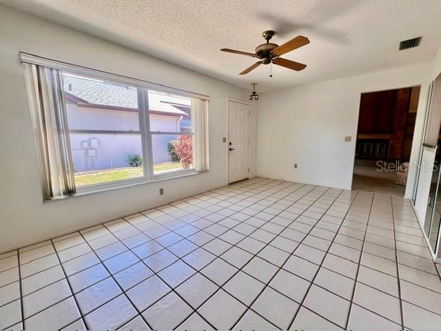 An empty room with white tile floors, a ceiling fan, and a large window — 641 LINDEN DRIVE UNIT 328, ENGLEWOOD, FL
