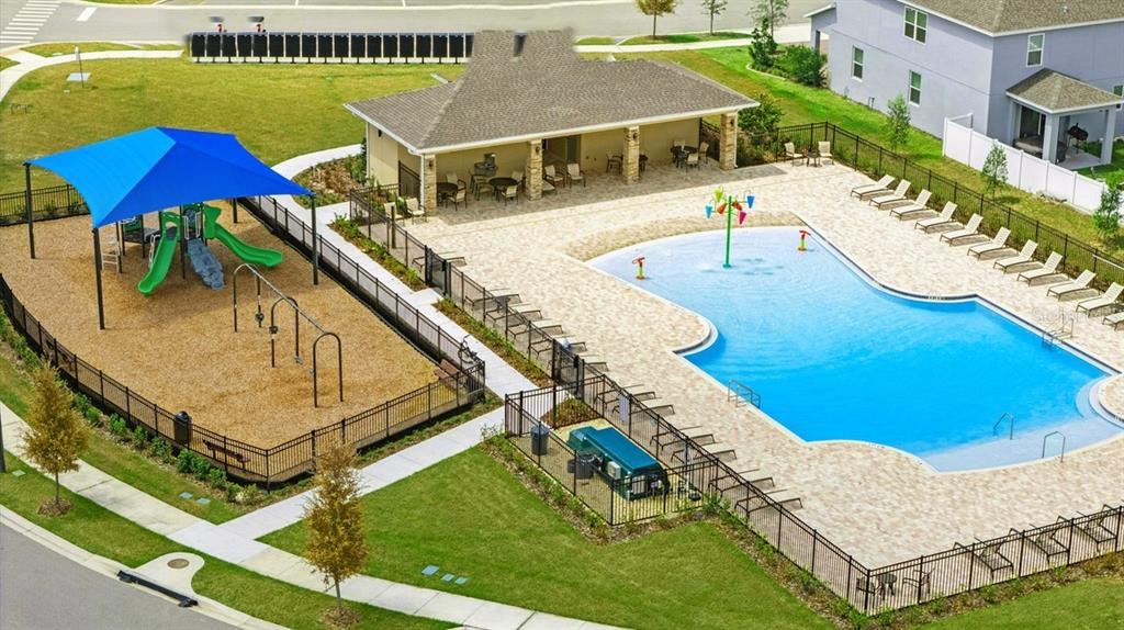 An aerial view shows a community swimming pool, a playground with a blue shade structure, and a clubhouse — 1113 MAJESTY PALM CIRCLE, DELAND, FL