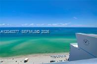 An elevated view shows a sandy beach and turquoise ocean next to a building exterior — 6899 Collins Ave # 2208, Miami Beach FL 33141, MIAMI BEACH, FL