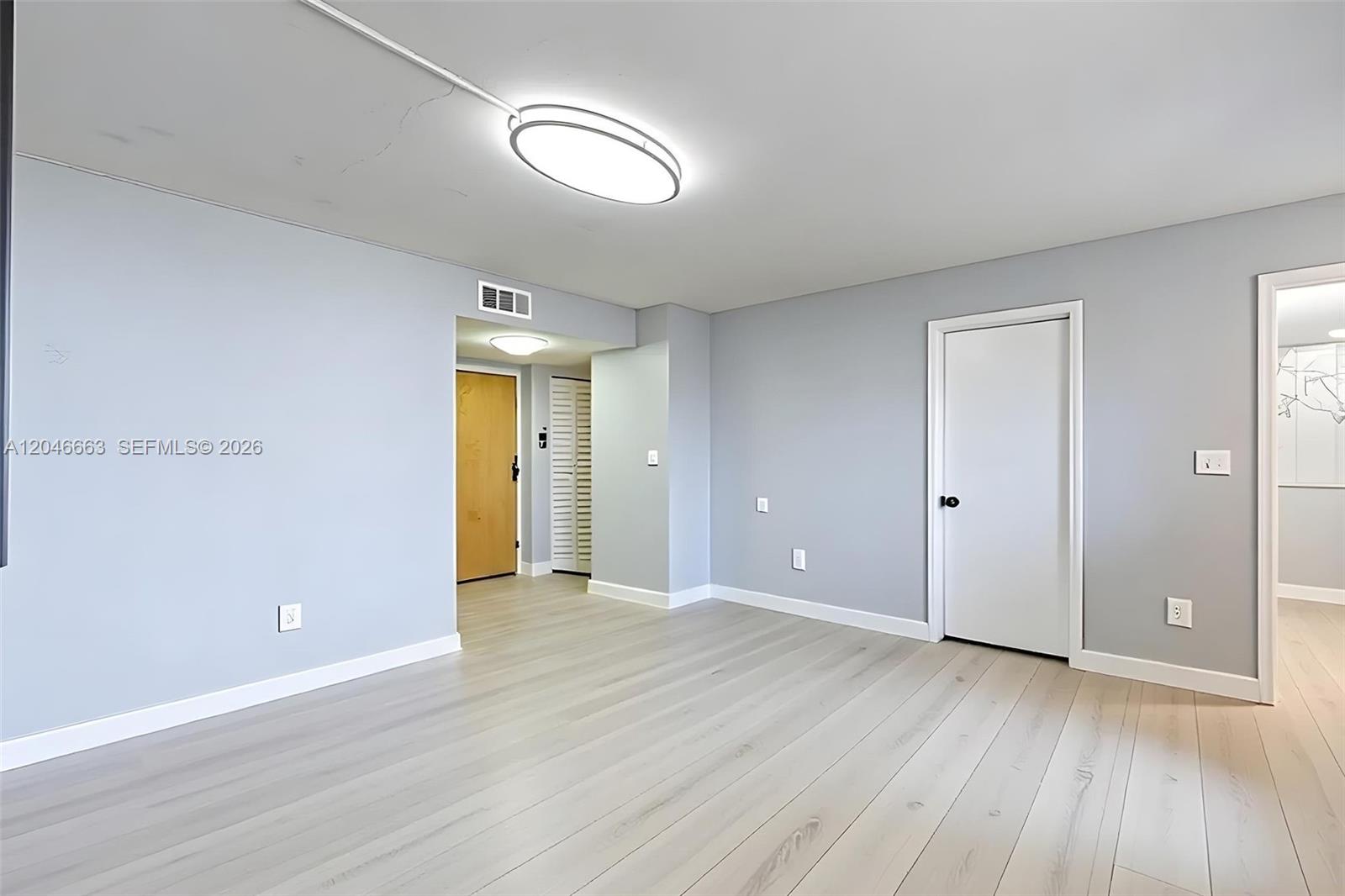 A light-gray room features light wood flooring, a central ceiling light, and white doors — 2075 SW 122nd Ave # 505, Miami FL 33175, MIAMI, FL