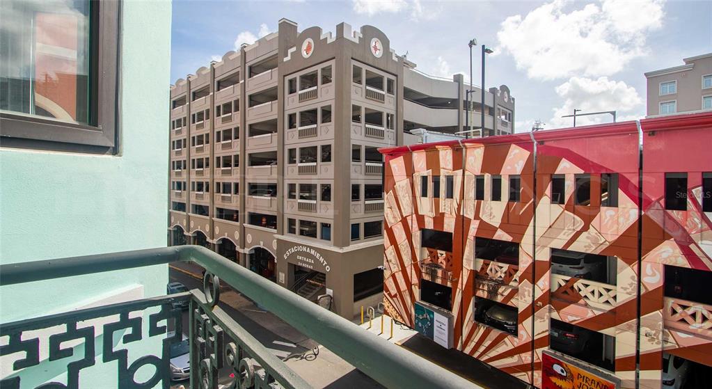 A view from a balcony overlooking a parking garage and a building with mural art — 319 RECINTO SUR STREET UNIT 6, SAN JUAN, PR