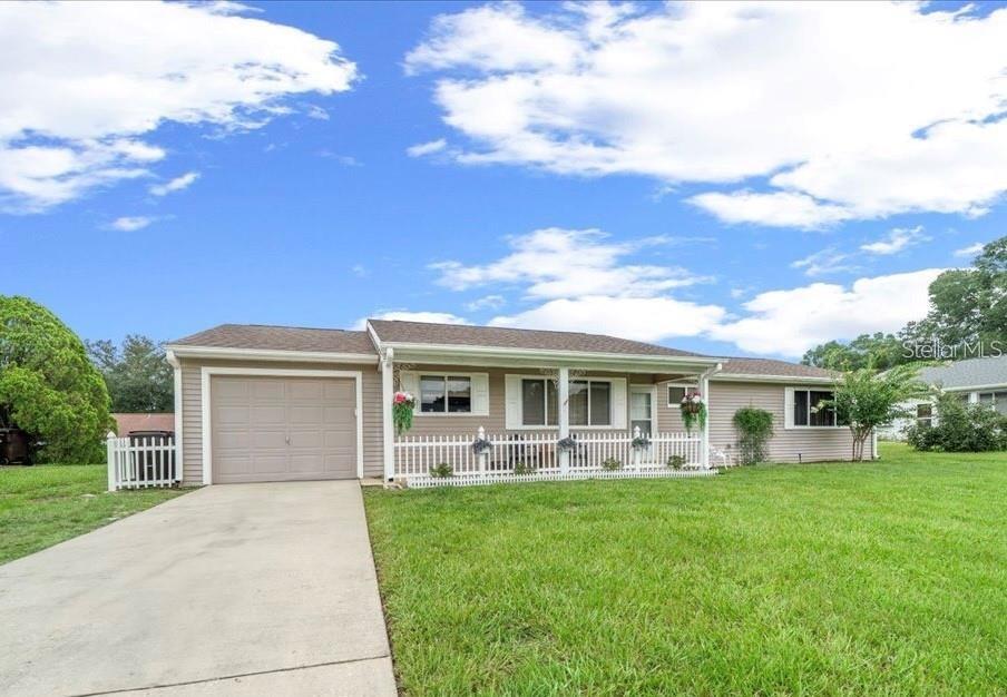 A single-story house with beige siding, a front porch, and an attached garage — 10820 SW 87TH TERRACE, OCALA, FL