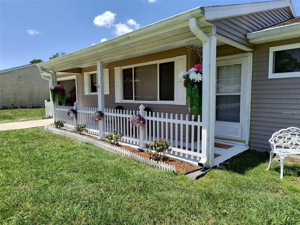 A house exterior features a white picket fence, a covered porch, and light-colored siding — 10820 SW 87TH TERRACE, OCALA, FL