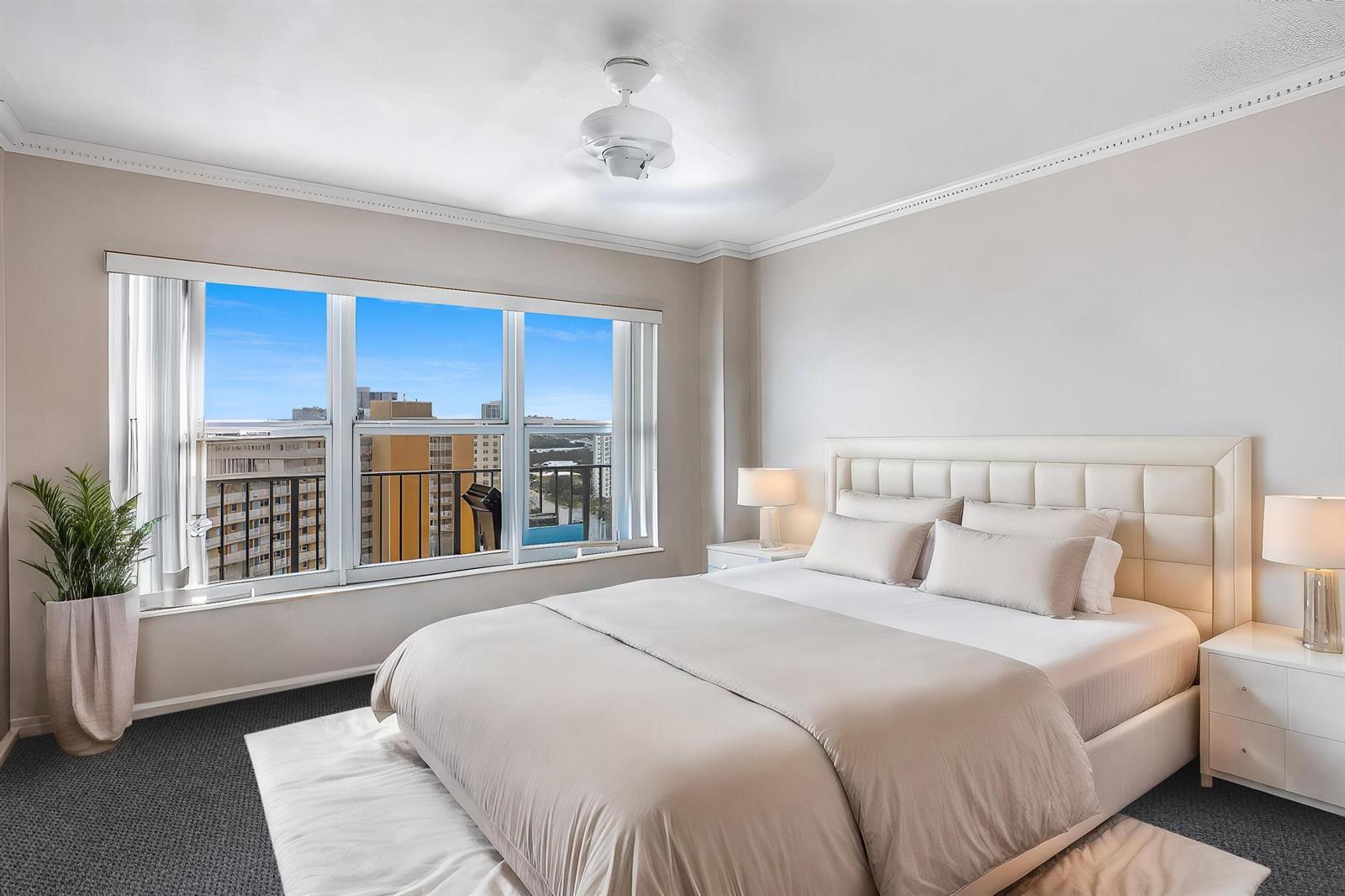 A living room with beige tile and carpet flooring, teal furniture, and an adjacent kitchen — 405 N Ocean Boulevard # 1704, Pompano Beach FL 33062, POMPANO BEACH, FL