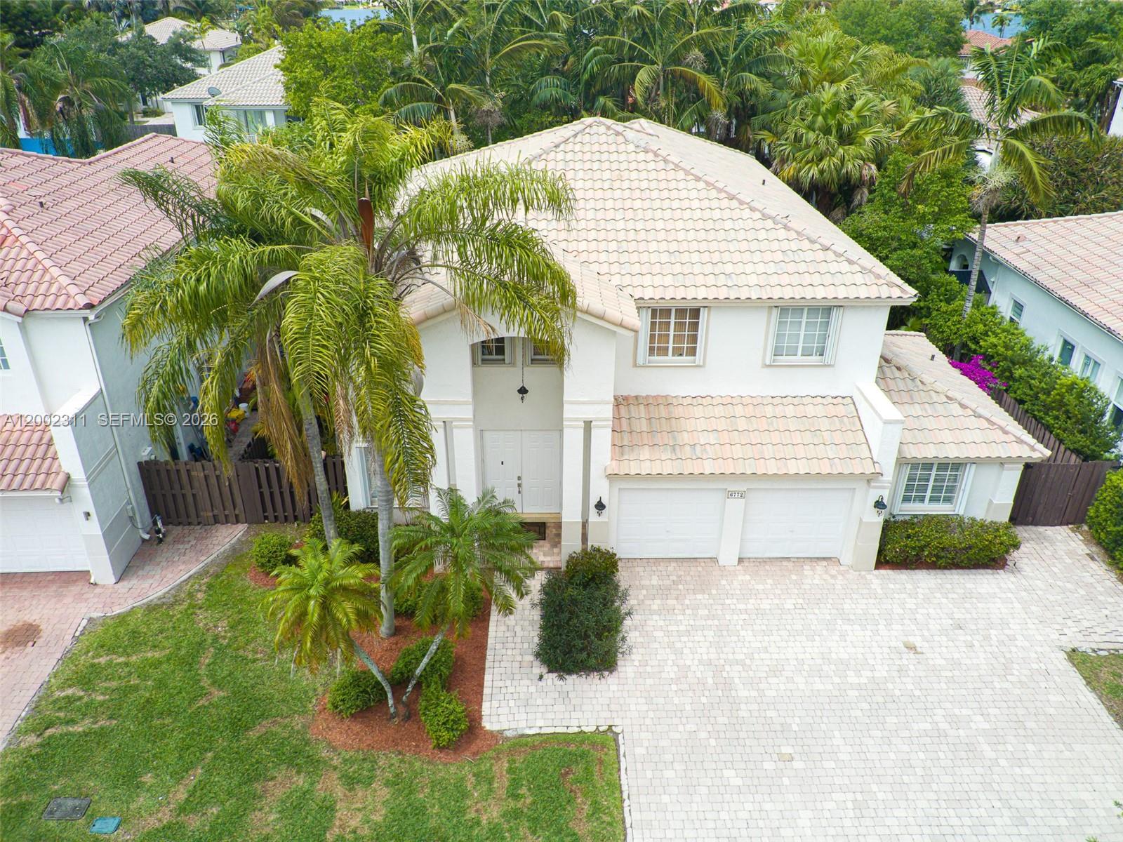 An aerial view shows a two-story white house with a tiled roof and palm trees — 6772 NW 111th Ave, Doral FL 33178, DORAL, FL