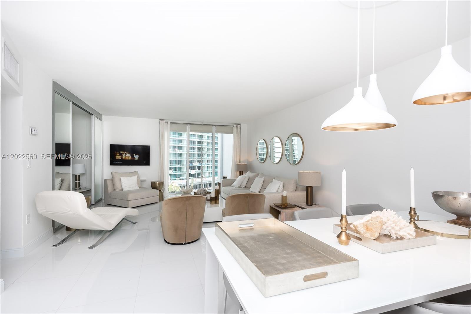 A bright, open-concept living and dining area features white tile floors and modern neutral furniture — 10275 Collins Ave # 706, Bal Harbour FL 33154, BAL HARBOUR, FL