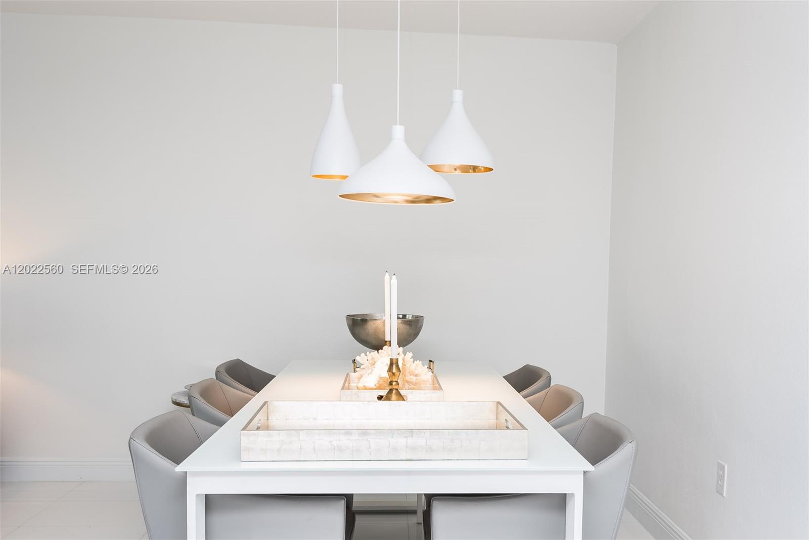 A dining room features a white table, gray chairs, and three white pendant lights — 10275 Collins Ave # 706, Bal Harbour FL 33154, BAL HARBOUR, FL