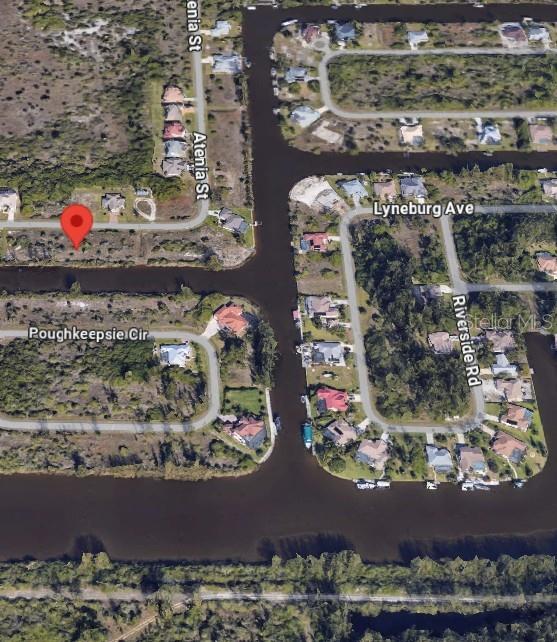 This aerial map shows a vacant residential lot marked with a pin near a canal — 10476 ATENIA STREET, PORT CHARLOTTE, FL