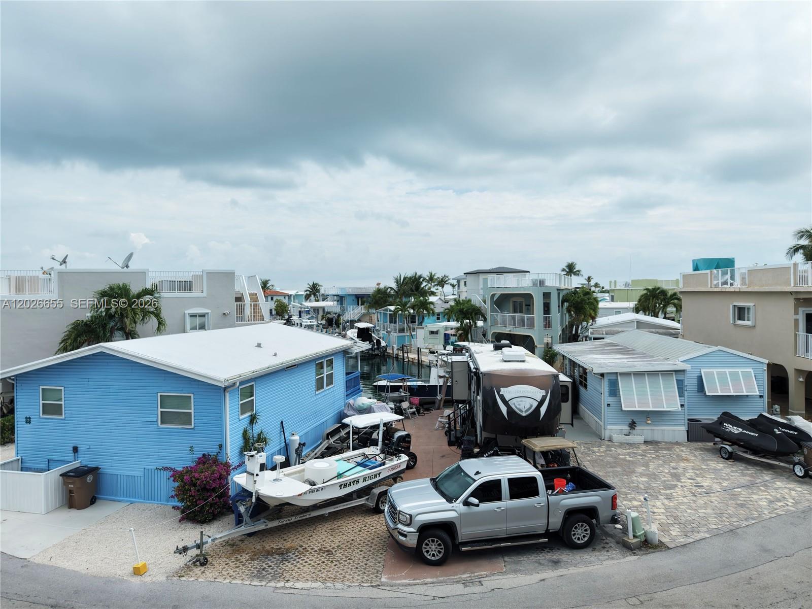 An elevated view shows two blue houses with a boat lift on a canal — 65821 Overseas Hwy #93, Long Key FL 33001, LONG KEY, FL