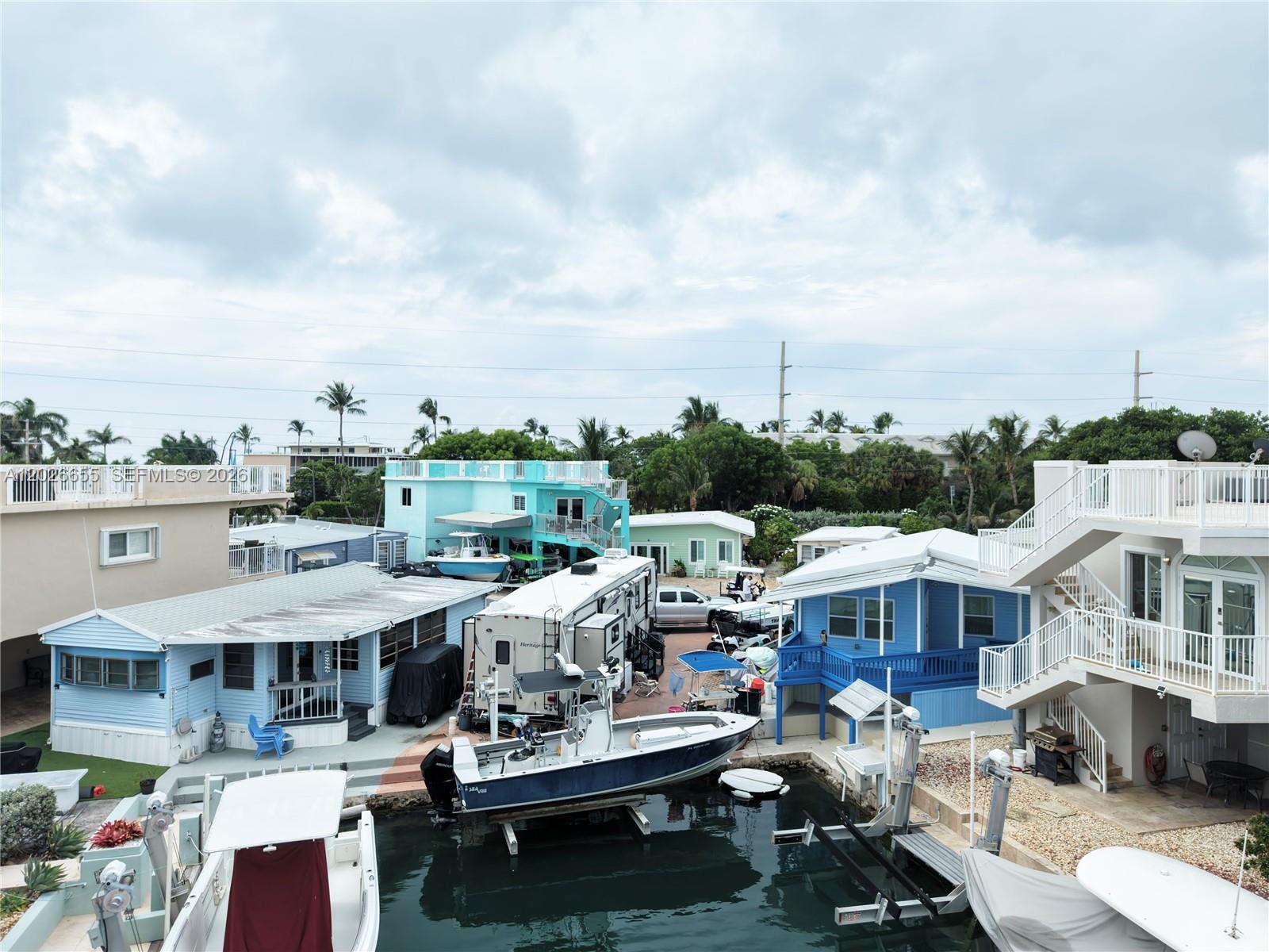 An elevated view shows two blue houses with a boat lift and dock area — 65821 Overseas Hwy #93, Long Key FL 33001, LONG KEY, FL