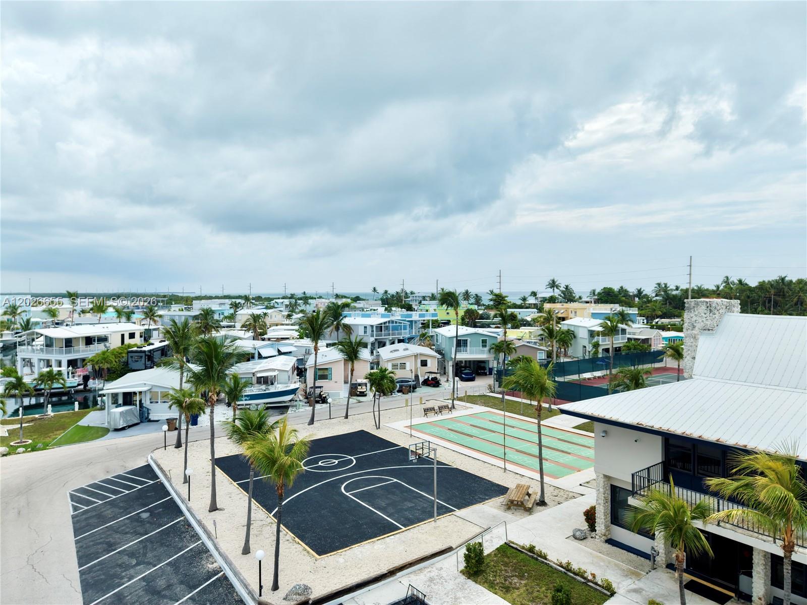 An aerial view shows a coastal neighborhood with numerous houses, boats, and palm trees — 65821 Overseas Hwy #93, Long Key FL 33001, LONG KEY, FL
