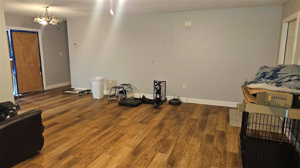 An interior room features wood-look flooring, light gray walls, and a ceiling light fixture — 18218 DRIGGERS AVENUE, PORT CHARLOTTE, FL
