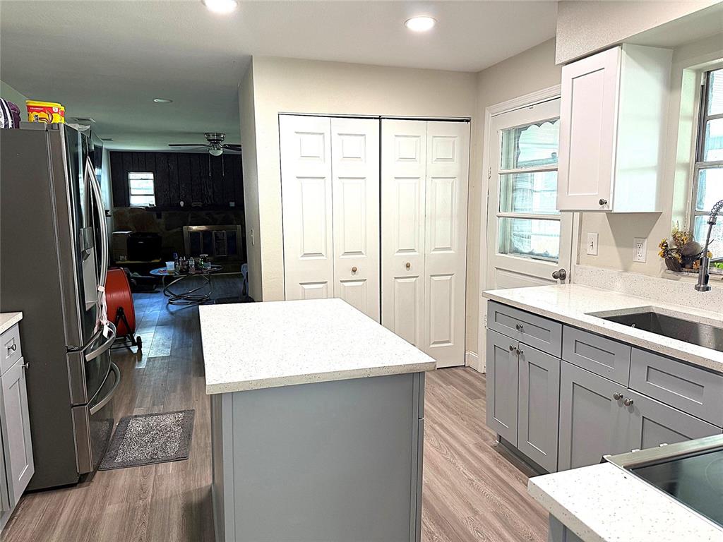 A kitchen features a central island, grey cabinets, white countertops, and light wood-look flooring — 39246 LIZABETH CIRCLE, ZEPHYRHILLS, FL